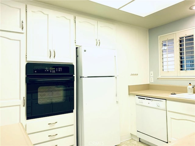 kitchen featuring white cabinetry, white appliances, and sink