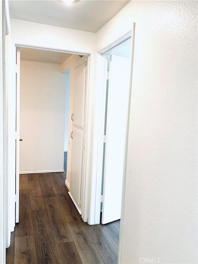 hallway with dark hardwood / wood-style floors