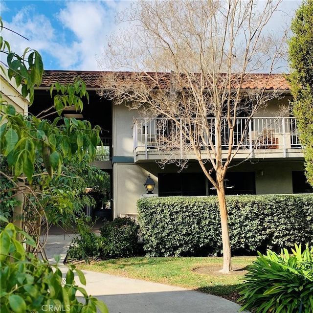 back of property featuring stucco siding, a garage, and a balcony