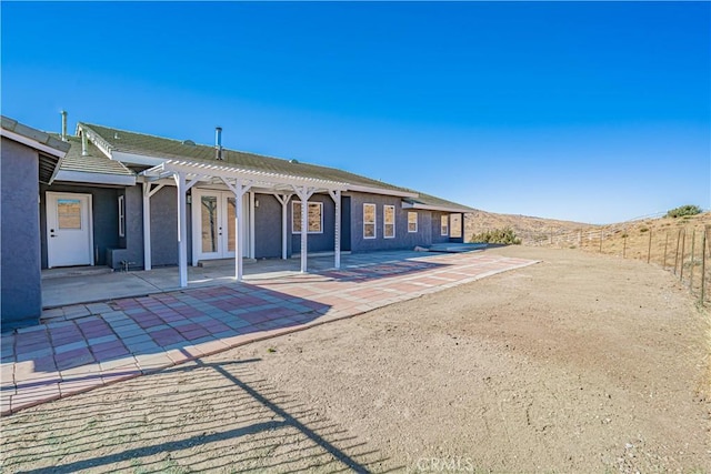 rear view of house with a mountain view, a pergola, and a patio