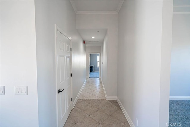 hallway featuring crown molding and light tile patterned floors