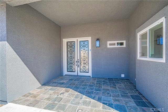 entrance to property featuring a patio and french doors