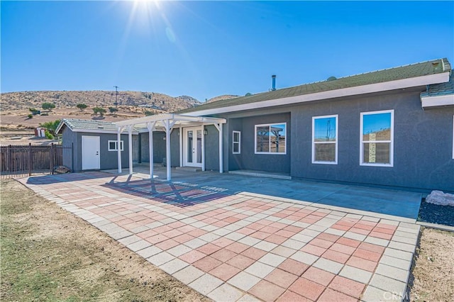 back of property featuring a pergola, a patio area, and a mountain view