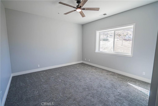 empty room with ceiling fan and dark colored carpet