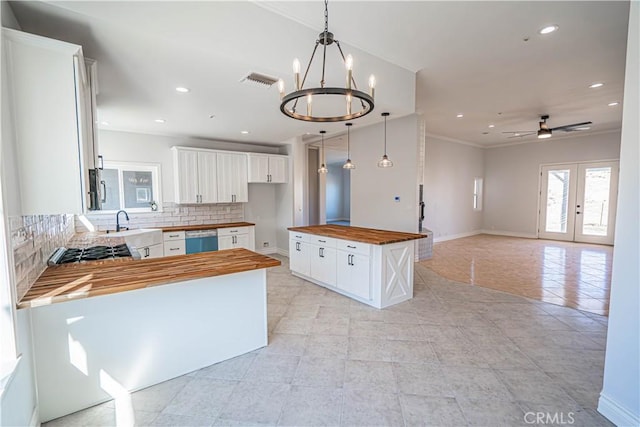 kitchen featuring white cabinetry, appliances with stainless steel finishes, a center island, and wooden counters