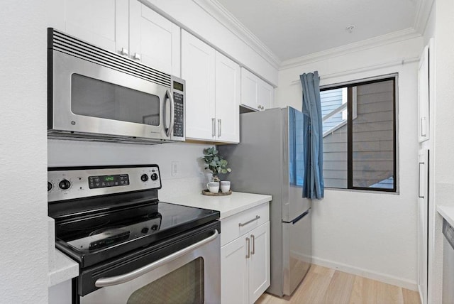 kitchen featuring white cabinetry, ornamental molding, appliances with stainless steel finishes, and light wood-type flooring