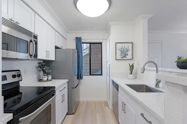 kitchen featuring white cabinetry, sink, crown molding, and stainless steel appliances