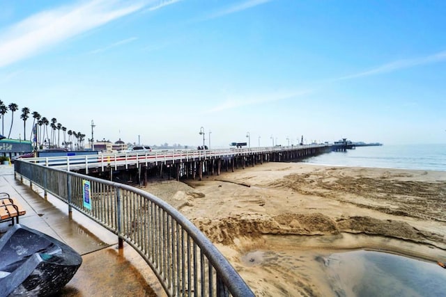 view of dock with a water view and a view of the beach