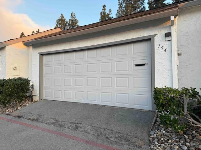 view of garage at dusk