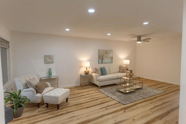 living room featuring ceiling fan and light hardwood / wood-style floors