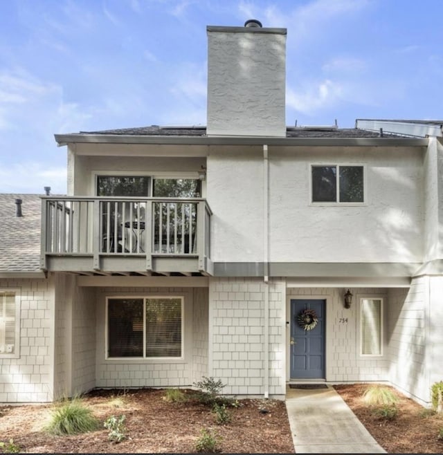 back of property with a balcony