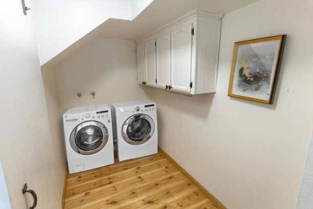 clothes washing area with cabinets, separate washer and dryer, and light wood-type flooring