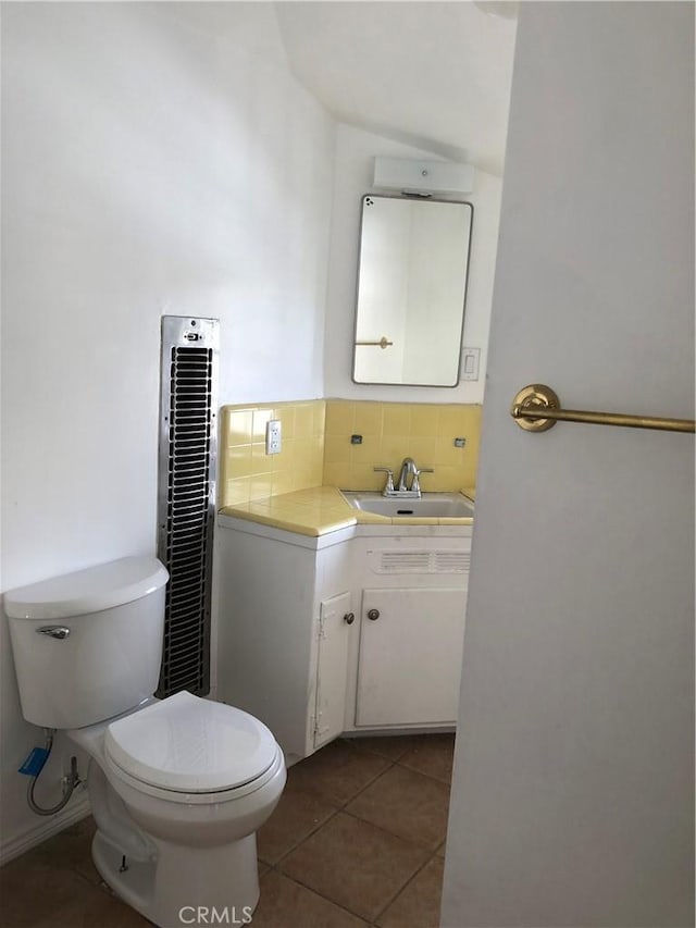 bathroom featuring tasteful backsplash, tile patterned floors, toilet, and vanity