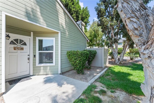 doorway to property featuring a patio area and a lawn