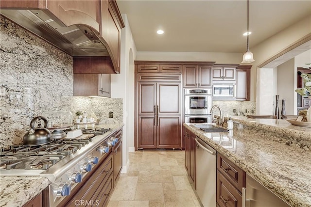 kitchen featuring hanging light fixtures, backsplash, built in appliances, light stone countertops, and custom exhaust hood