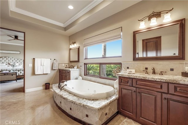 bathroom featuring vanity, a relaxing tiled tub, a raised ceiling, crown molding, and tile patterned floors