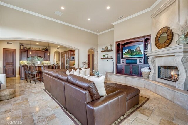 living room with crown molding and a fireplace