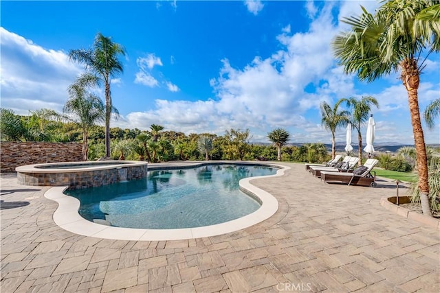 view of swimming pool featuring an in ground hot tub and a patio area