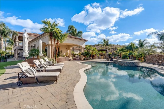 view of swimming pool featuring a patio and an in ground hot tub