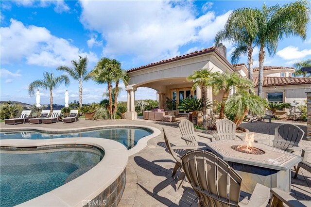 view of pool with a patio, an outdoor living space with a fire pit, and an in ground hot tub