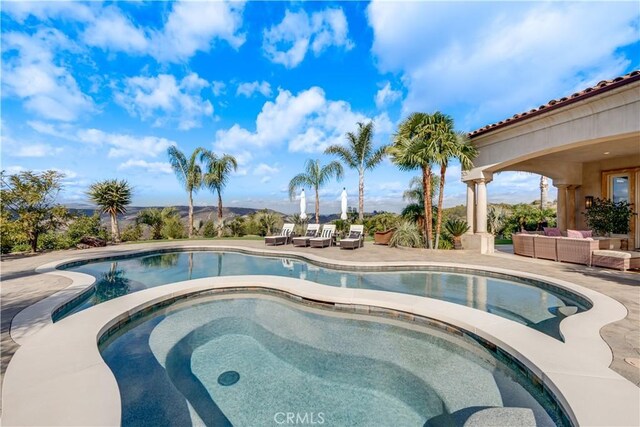 view of pool featuring an outdoor hangout area, a patio, and an in ground hot tub