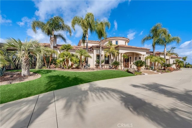 mediterranean / spanish home with a front lawn