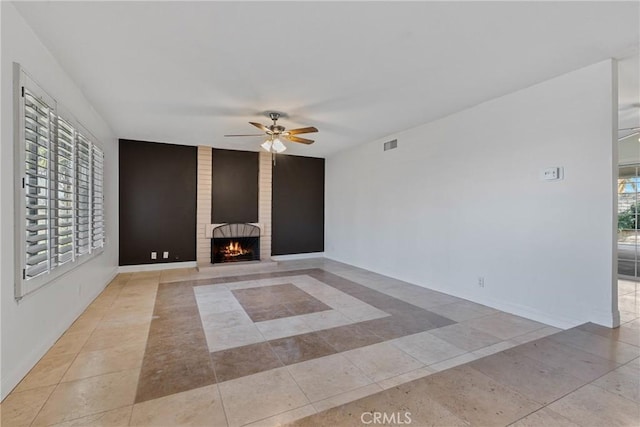 unfurnished living room with light tile patterned floors, a fireplace, and ceiling fan