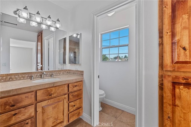 bathroom featuring vanity, tile patterned flooring, and toilet