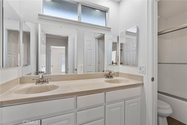 full bathroom with vanity, toilet, and combined bath / shower with glass door