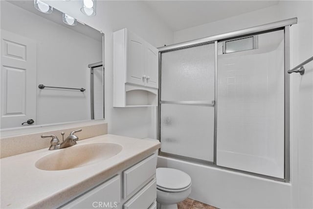 full bathroom featuring bath / shower combo with glass door, vanity, tile patterned floors, and toilet