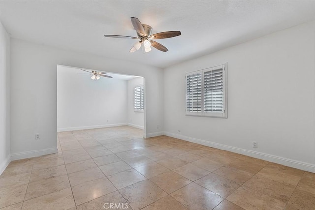 spare room with ceiling fan and light tile patterned flooring