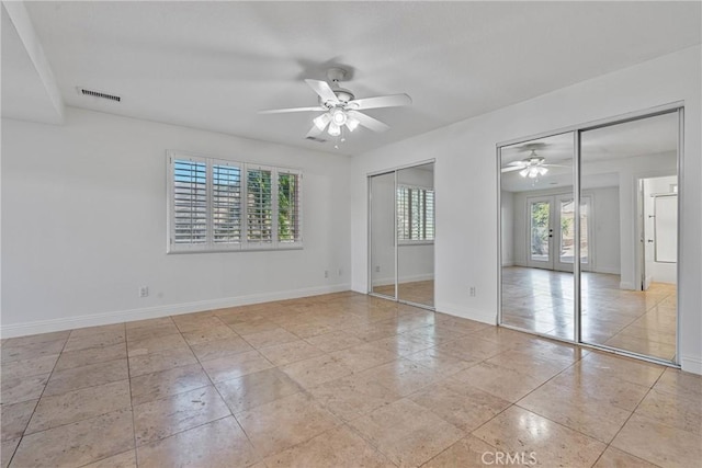 spare room with light tile patterned floors, a wealth of natural light, french doors, and ceiling fan