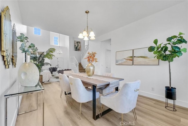 dining room featuring light wood-type flooring and an inviting chandelier