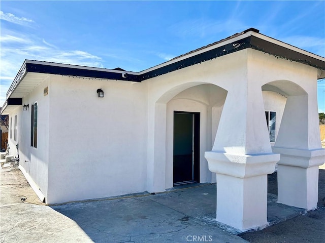 entrance to property featuring stucco siding