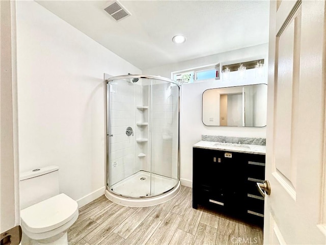 bathroom with visible vents, a shower stall, toilet, and wood finished floors