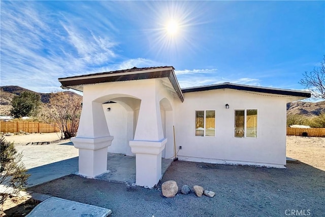 view of front of house featuring fence and stucco siding