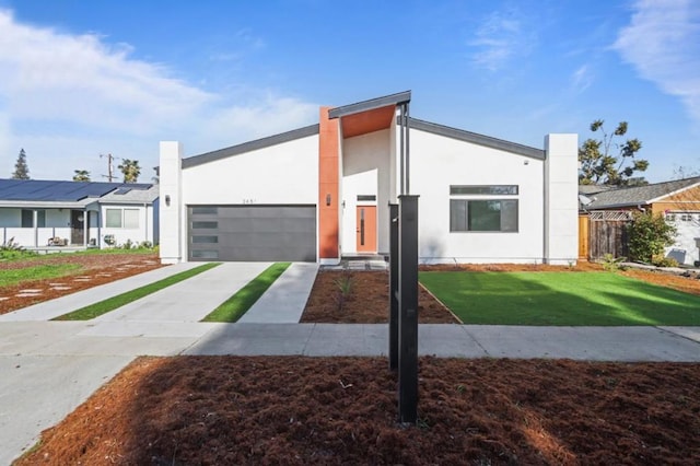 contemporary house featuring a garage and a front lawn