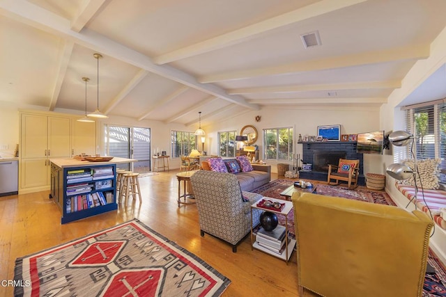 living room featuring vaulted ceiling with beams and light wood-type flooring