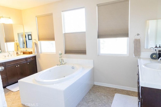 bathroom with a jetted tub, a sink, and two vanities