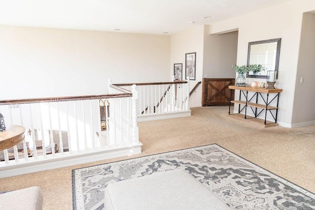 hallway featuring a wealth of natural light, an upstairs landing, carpet floors, and baseboards