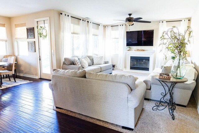 living room with dark hardwood / wood-style flooring and ceiling fan