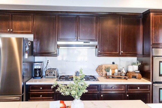 kitchen with stainless steel appliances and decorative backsplash