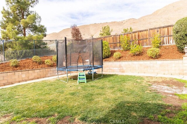 view of yard featuring a mountain view and a trampoline