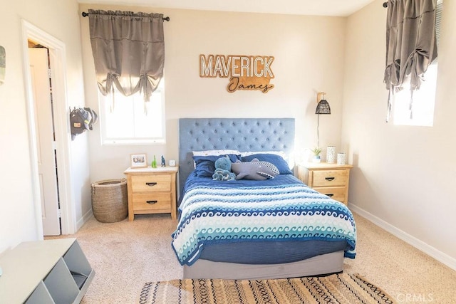 bedroom featuring multiple windows, baseboards, and carpet flooring