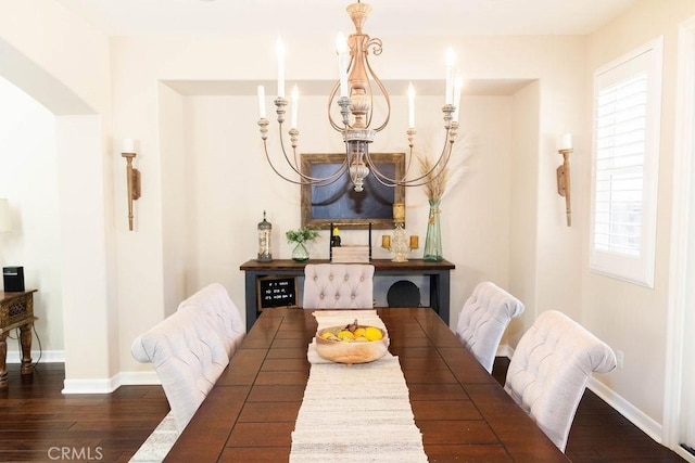 dining room featuring baseboards, wood finished floors, and a chandelier