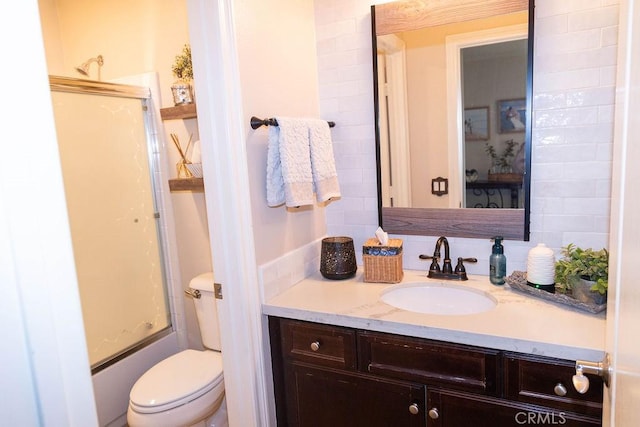 bathroom with toilet, bath / shower combo with glass door, and vanity