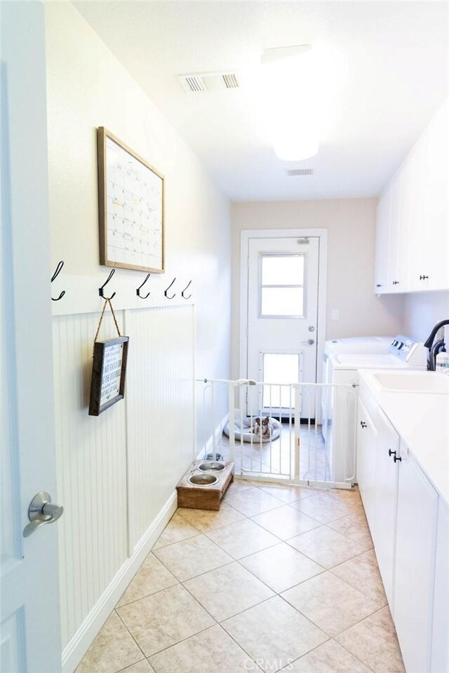 washroom with cabinets, light tile patterned flooring, and washer and clothes dryer