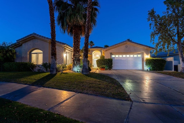 mediterranean / spanish-style house with a garage and a yard