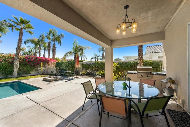 view of patio featuring a fenced in pool, an outdoor kitchen, and grilling area