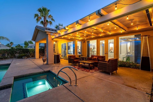 pool at dusk featuring an in ground hot tub, an outdoor hangout area, and a patio area